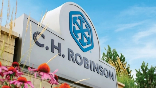 C.H. Robinson company sign with blue logo displayed on a white monument outside a building with flowers